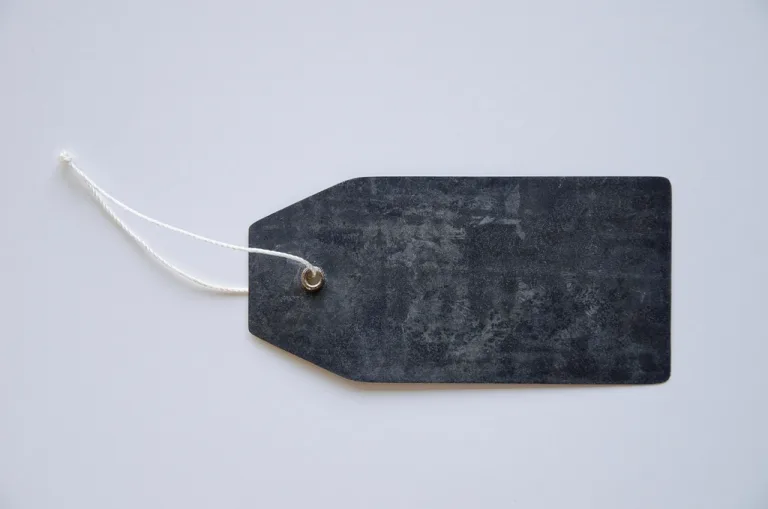 Blank dark gray product tag with a white string on a light background