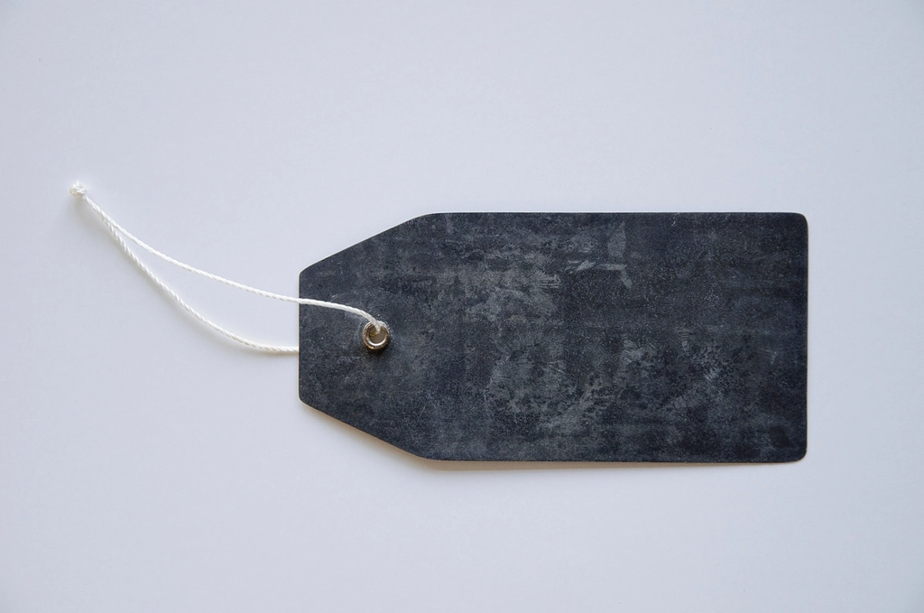 Blank dark gray product tag with a white string on a light background