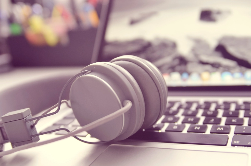 White headphones resting on a laptop keyboard