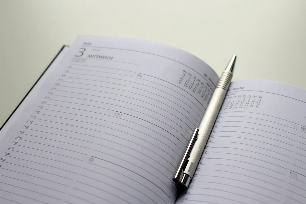 Open daily planner with a silver pen resting on the page